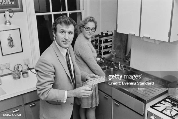 English television journalist Julian Pettifer fills up on ice cubes, watched by Joyce, UK, January 1971.