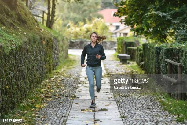 woman jogging and exercising in the park - track suit stock pictures, royalty-free photos & images