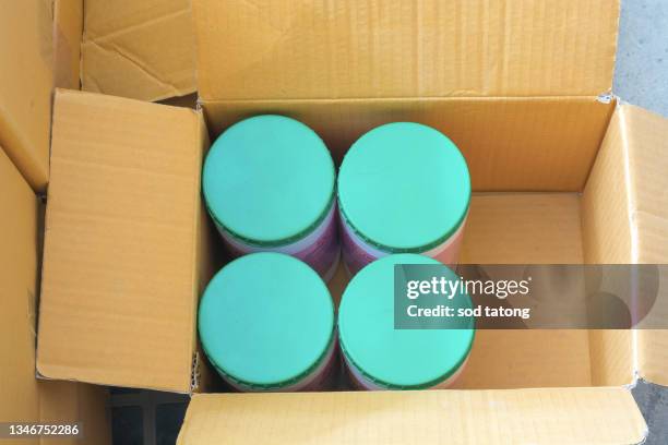high-angle close-up view of the hands of a manufacturing worker putting packed products, in cardboard boxes before export or shipping during manual work - hands holding open box top view stock pictures, royalty-free photos & images