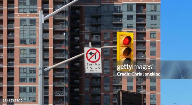 red traffic signal and no left turning sign - toronto sign stock pictures, royalty-free photos & images