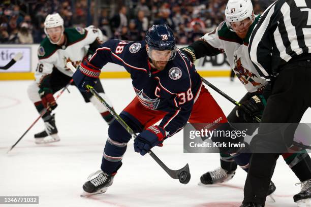 Boone Jenner of the Columbus Blue Jackets wins a faceoff against Lawson Crouse of the Arizona Coyotes during the game at Nationwide Arena on October...