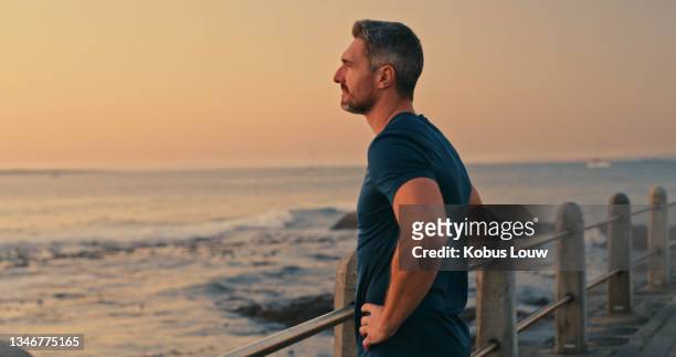 shot of a mature man looking thoughtful while admiring the view along the promenade - beach pavilion stock pictures, royalty-free photos & images