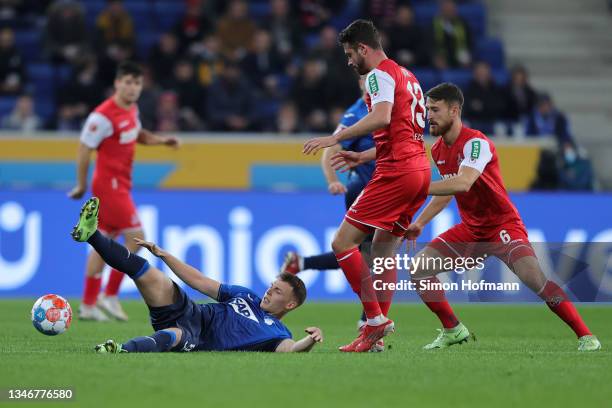 Dennis Geiger of Hoffenheim is tackled by Mark Uth of Koln during the Bundesliga match between TSG Hoffenheim and 1. FC Köln at PreZero-Arena on...