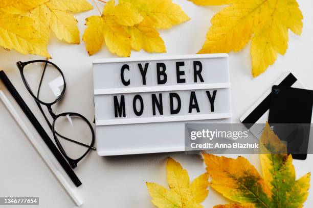 cyber monday symbol. lightbox with text cyber monday, eyeglasses, payment cards and pencils. - サイバーマンデー ストックフォトと画像