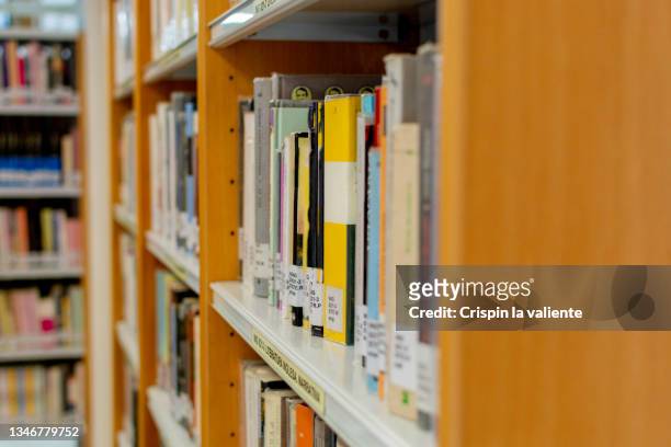 public library, shelf with books - öffentliche bibliothek stock-fotos und bilder