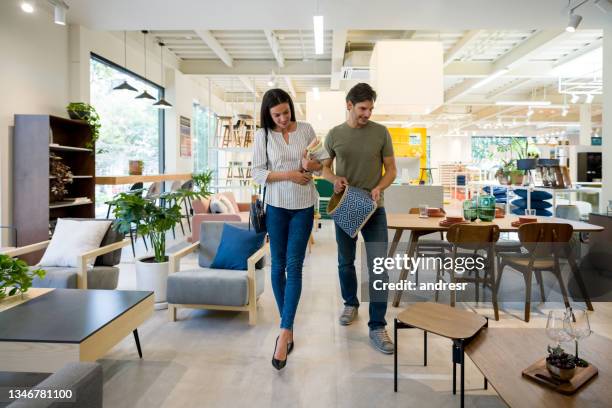 newlywed couple shopping decor for their house at a furniture store - loja de móveis imagens e fotografias de stock