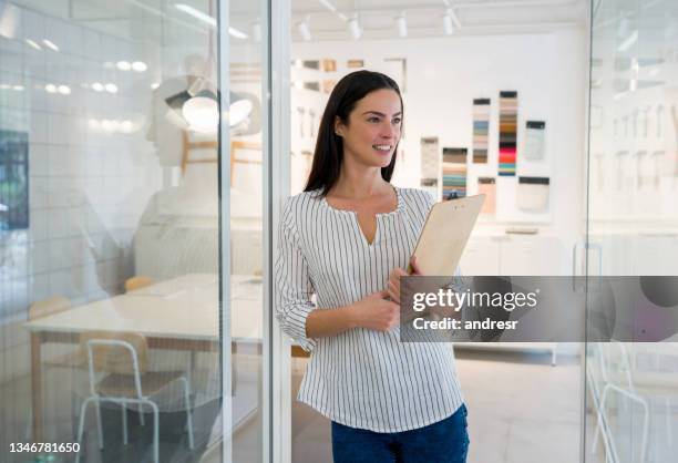 nachdenkliche innenarchitektin, die in ihrem büro arbeitet - showroom stock-fotos und bilder