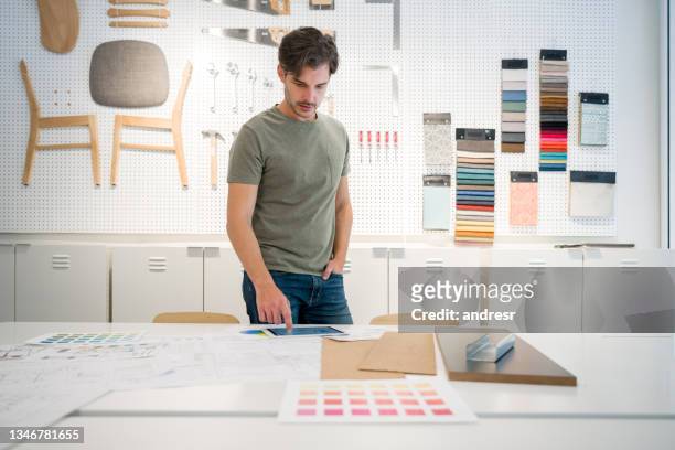 diseñador de interiores mirando fotos en su tableta en la oficina - fine furniture fotografías e imágenes de stock