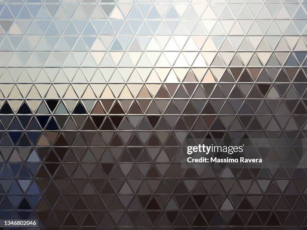 metallic surface reflecting sunset. - building triangle stock pictures, royalty-free photos & images
