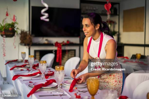 mujer latina decora las mesas de una fiesta - organizador de eventos fotografías e imágenes de stock