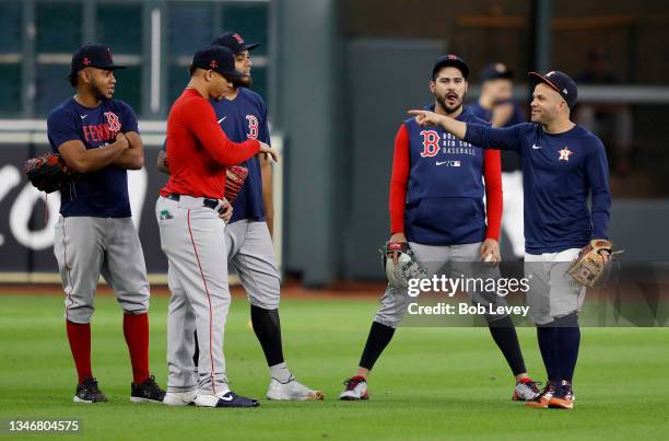 Jose Altuve of the Houston Astros jokes around with players from the Boston Red Sox before Game One of the American League Championship Series at...