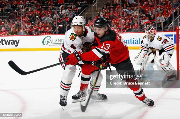 Seth Jones of the Chicago Blackhawks holds back Nico Hischier of the New Jersey Devils during the second period at the Prudential Center on October...