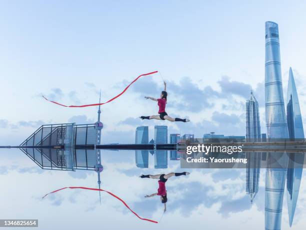 young female ballet dancer dancing with a red ribbon on a rooftop in shanghai,china - ribbon dance stock pictures, royalty-free photos & images