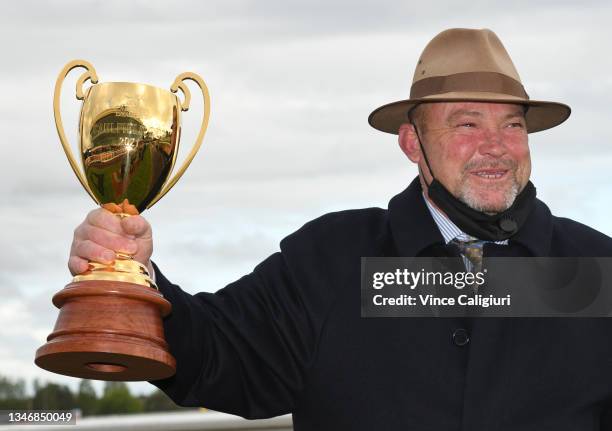 Trainer Peter Moody poses with the Caulfield Cup after Incentivise won Race 9, the Carlton Draught Caulfield Cup, during Caulfield Cup Day at...