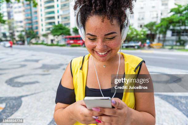 a chubby sportswoman walks around town - woman headphones sport smile iphone stock pictures, royalty-free photos & images