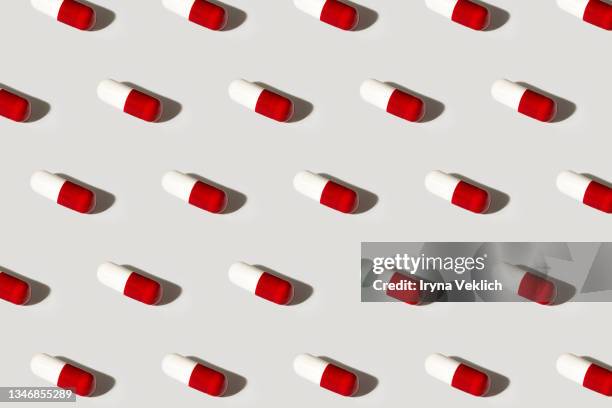 pills background, white and red capsules pattern on a grey color. - exercise pill stock-fotos und bilder