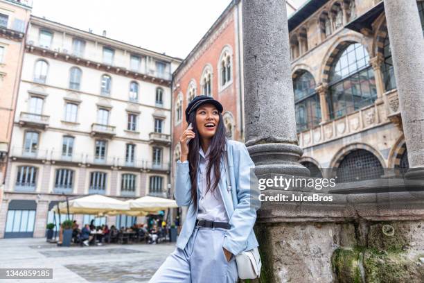 smiling young woman talking on the phone on the street - milan street fashion 2019 imagens e fotografias de stock