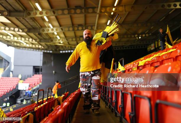 Watford FC fan is seen placing flags in the home stand seats prior to the Premier League match between Watford and Liverpool at Vicarage Road on...