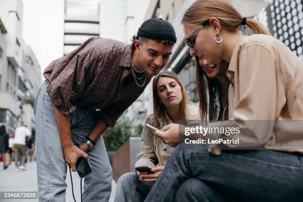 group of generation z friends looking on social media - gen z shopping stock pictures, royalty-free photos & images