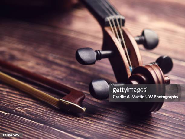 antique violin on an old wooden floor - bow musical equipment stock pictures, royalty-free photos & images