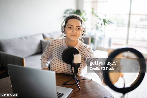 young woman doing a live broadcast at home - emcee imagens e fotografias de stock