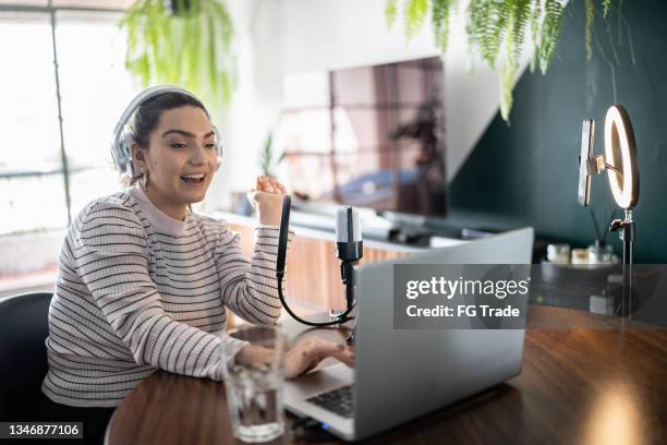 mujer joven haciendo una transmisión en vivo en casa - maestro de ceremonias fotografías e imágenes de stock