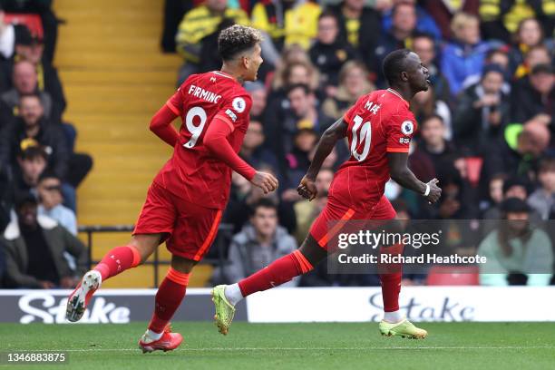 Sadio Mane of Liverpool is chased by Roberto Firmino after scoring their side's first goal during the Premier League match between Watford and...