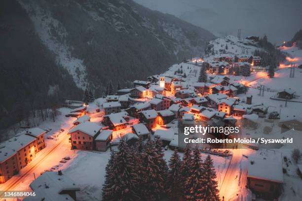 mountain village covered with snow at night in winter - isola stock-fotos und bilder