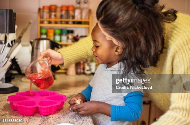 mamãe e seu filhozinho fofo fazendo uma sobremesa de gelatina em casa - gelatina sobremesa - fotografias e filmes do acervo