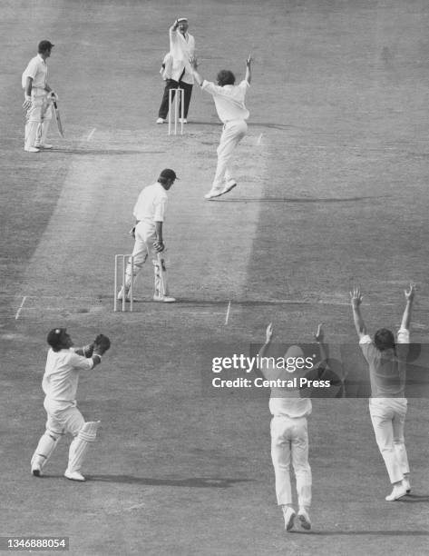 Umpire Tom Spencer raises the finger to Brian Luckhurst of England as he is dismissed LBW for 23 off the bowling of Dennis Lillee as wicketkeeper...