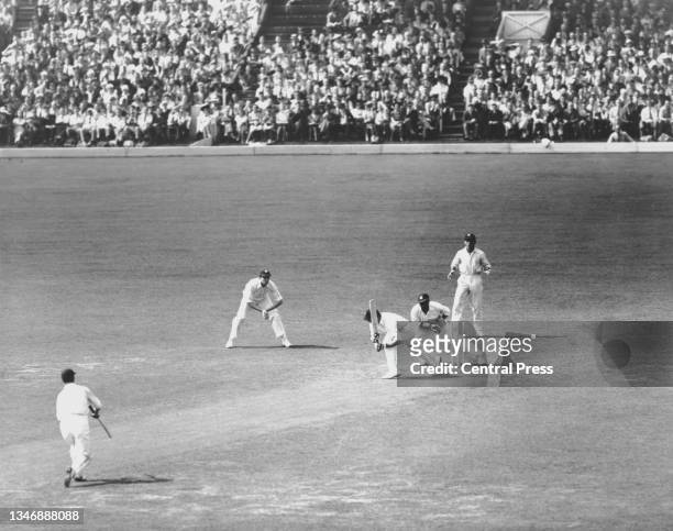 Derek Sealy, wicketkeeper for the West Indies attempts to stump Wally Hammond, right handed batsman and captain for England as he plays a shot during...