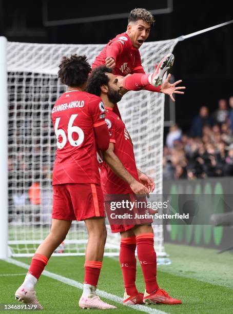 Mohamed Salah of Liverpool celebrates with teammates Trent Alexander-Arnold and Roberto Firmino after scoring their side's fourth goal during the...