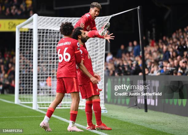 Mohamed Salah of Liverpool celebrates with teammates Trent Alexander-Arnold and Roberto Firmino after scoring their side's fourth goal during the...