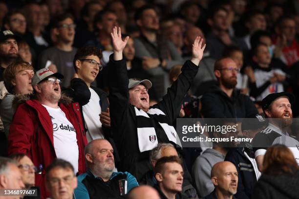 Fulham fans celebrate during the Sky Bet Championship match between Fulham and Queens Park Rangers at Craven Cottage on October 16, 2021 in London,...