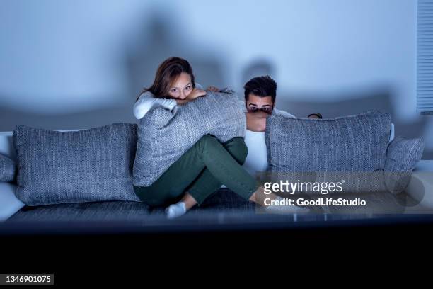 pareja viendo una película de terror - horror movie fotografías e imágenes de stock