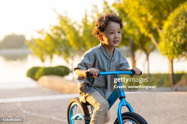 a little boy riding a bicycle - alleen jongens stockfoto's en -beelden