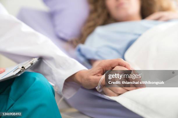 doctor holding patient's hand, encourage patients to sleep on the bed in hospital.helping hand concept. - bed sleep stockfoto's en -beelden