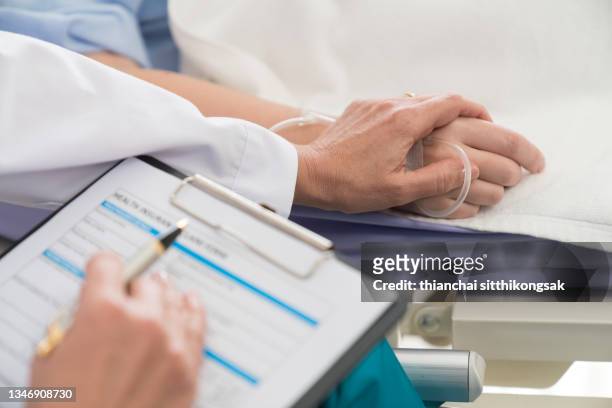 close up of hand doctor encourage woman patient by holding hand on the bed in hospital. - ethical treatment foto e immagini stock