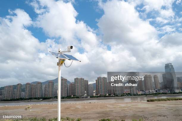 a remote camera powered by solar panels at the waterside of the city - city sensors stock pictures, royalty-free photos & images