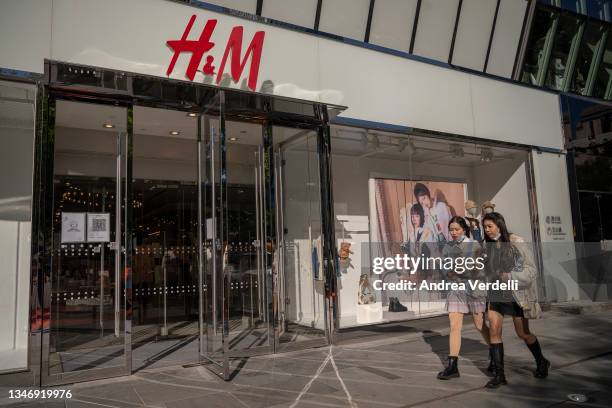 People walk in front of a H&M store on October 16, 2021 in Beijing, China. According to an action plan released on October 14, Beijing has unveiled a...