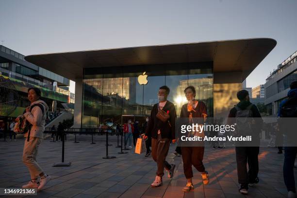People walk in front of an Apple Store on October 16, 2021 in Beijing, China. According to an action plan released on October 14, Beijing has...