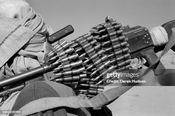 Close-up of an automatic rifle wrapped in an ammunition belt, Kabul Province, Afghanistan, October 2001.