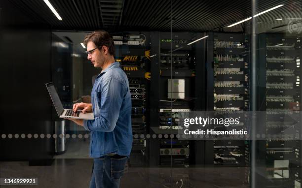 it-techniker, der einen ausfall auf einem netzwerkserver behebt - datacenter stock-fotos und bilder