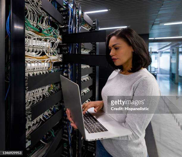 ingegnere informatico che ripara un server di rete in un ufficio - server room women foto e immagini stock