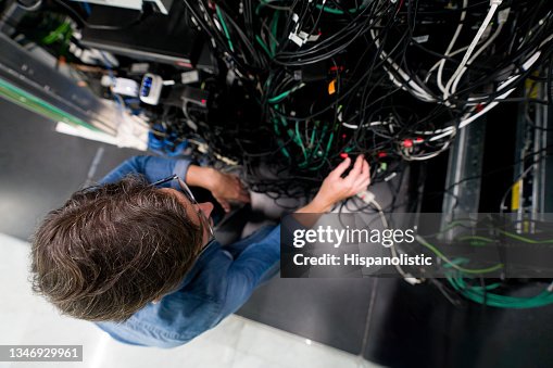 Computer engineer fixing a problem in the server room Computer engineer fixing a problem in the server room