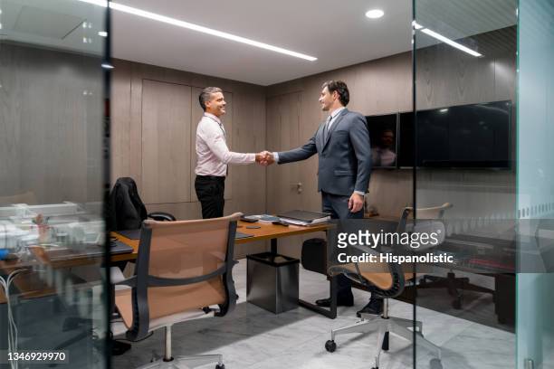 business men in a meeting closing a deal with a handshake - barrister stockfoto's en -beelden