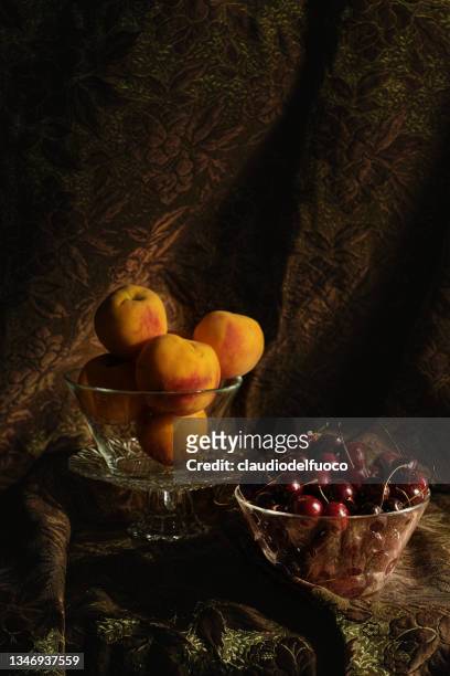 still life - peaches and cherries in glass bowls - lamp shade fotografías e imágenes de stock