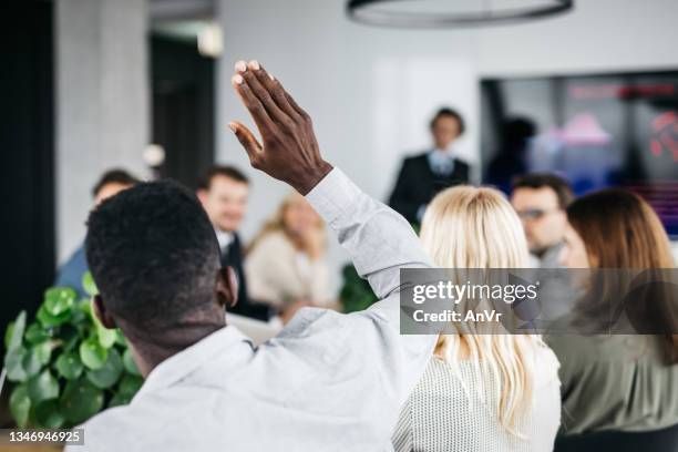 young businessman raising his hand at a meeting - obscured face stock pictures, royalty-free photos & images