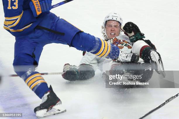 Ryan Dzingel of the Arizona Coyotes falls and nearly trips Mark Pysyk of the Buffalo Sabres during the third period at KeyBank Center on October 16,...