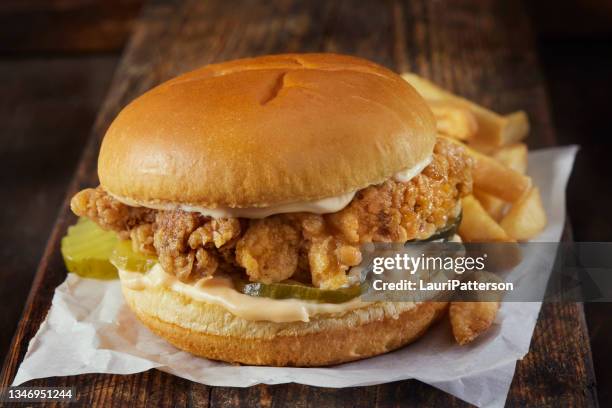 spicy crispy fried chicken burger with french fries - gefrituurde kip stockfoto's en -beelden